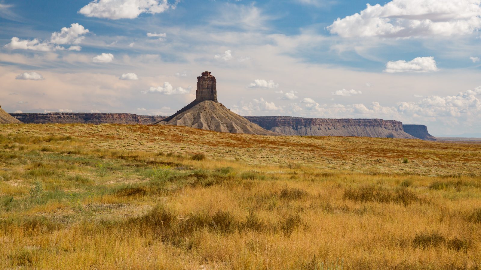 Open high-desert rangeland and a sandstone butte in Southwest Colorado
