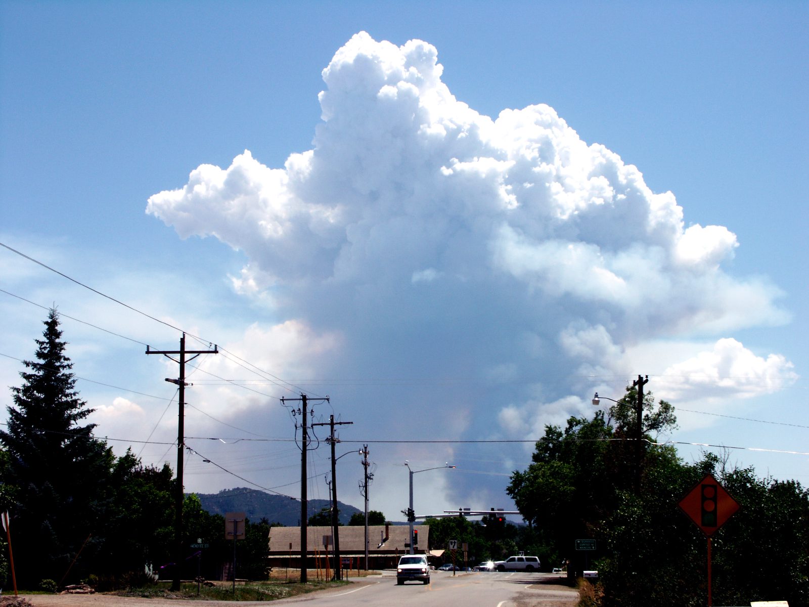 A towering summer thunderhead rising over a town in Southwest Colorado